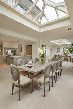 a dining room table with six chairs and a skylight