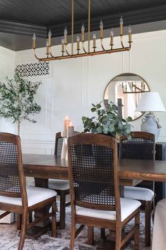 a dining room table with chairs and a potted plant