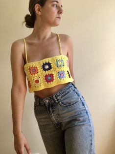 a woman wearing jeans and a crocheted crop top