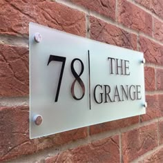 a house number sign mounted to the side of a brick building