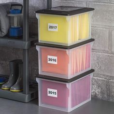 three plastic containers stacked on top of each other in front of a gray brick wall