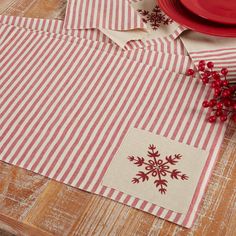 red and white striped placemats with snowflakes on them next to a plate