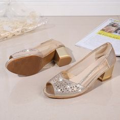 a pair of women's shoes sitting on top of a table next to papers