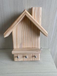 a wooden bird house with three screws on the side