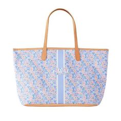 a blue and white bag with flowers on the front, stripes down the side and tan leather handles