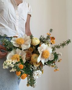 a woman holding a bouquet of flowers in her hands