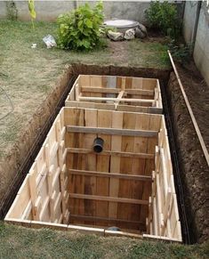 an unfinished wooden structure in the middle of a yard with grass and dirt around it