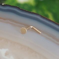 a close up of a piece of jewelry on a white and gold plated object