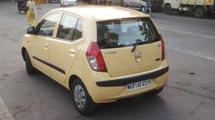 a small yellow car is parked on the street