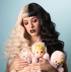 a woman with long hair holding three stuffed animals