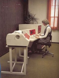 a woman sitting at a desk using a computer