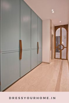 an empty hallway with blue cabinets and wooden handles on the doors is pictured in this image