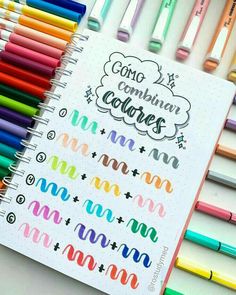 colorful crayons are lined up next to a notebook with the words concognin corres written on it