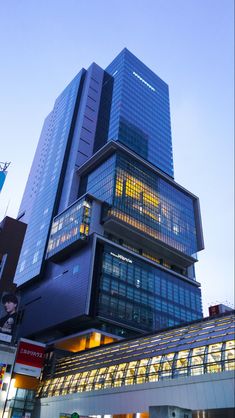 a very tall building with many windows on it's side in front of other buildings