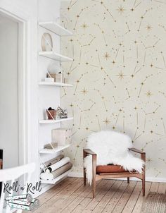 a white chair sitting in front of a wall with gold stars on it