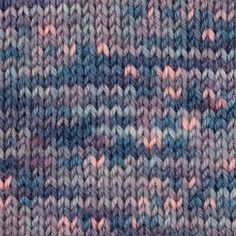 a close up view of a knitted fabric with pink, blue and grey colors