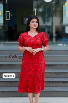 a woman in a red dress standing on steps