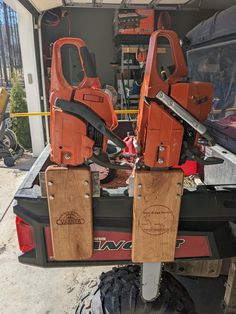 two chainsaws are attached to the back of a vehicle