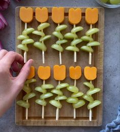 a person is picking up some fruit from a tray