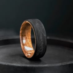 a wooden ring sitting on top of a black surface