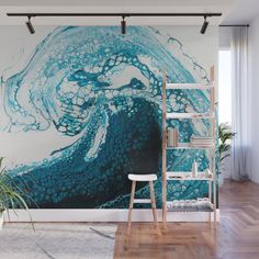 an ocean wave with blue and white paint on it wall mural in a living room