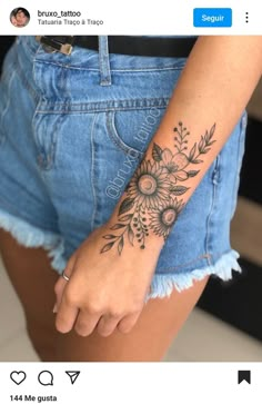 a woman's arm with flowers tattooed on it