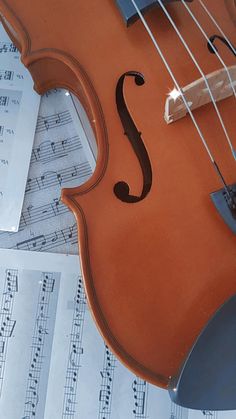 an orange violin sitting on top of sheet music