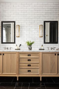 a bathroom with two sinks and three mirrors on the wall next to each other in front of a white brick wall