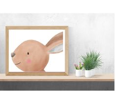 a painting of a rabbit in a wooden frame on a shelf next to potted plants