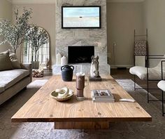 a living room filled with furniture and a flat screen tv mounted on the wall above a fireplace