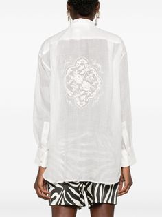 Find ZIMMERMANN Alight Floral-embroidered Shirt on Editorialist. ivory white ramie/cotton semi-sheer construction floral embroidery to the rear classic collar mother-of-pearl buttons drop shoulder long sleeves buttoned cuffs curved hem This item contains at least 50% materials which are certified or widely recognised as having a lower environmental impact through production and/or manufacturing processes that reduce water consumption and the use of harmful chemicals, or re-use by-products of the production process. Learn more about what makes a product Conscious on our Conscious Criteria page Elegant Summer Top With Chikankari Embroidery, Elegant Summer Chikankari Embroidered Top, Elegant Chikankari Embroidered Top For Summer, White Long Sleeve Embroidered Top For Wedding, White Long Sleeve Embroidered Wedding Top, Elegant Summer Top With Intricate Embroidery, Elegant White Embroidered Top With Floral Detail, White Embroidered Blouse With Relaxed Fit, Elegant Spring Blouse With Tonal Embroidery