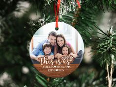 a christmas ornament hanging on a tree with a family photo in the center