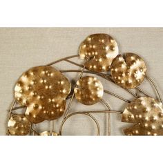 a metal sculpture with gold leaves on it's sides and dots in the middle