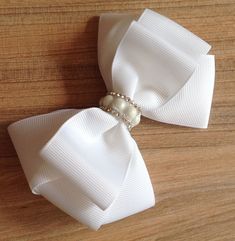 a close up of a bow tie with pearls on it's lapel pin