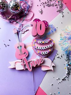 a pink and purple birthday cake topper with the number 80 on it, surrounded by confetti