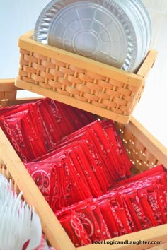 a basket filled with red and white plates next to another basket full of silverware