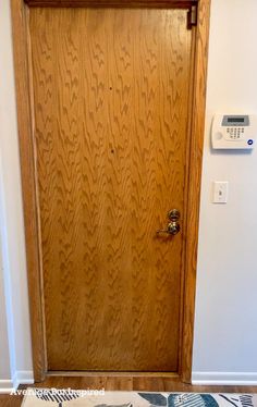 a wooden door with an air conditioner on top of it and a rug underneath