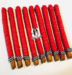 six red corn cobs with black and white checkered tape on them, each containing pickles