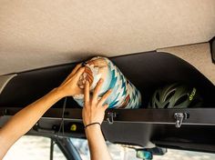 a person is holding a pillow in the back of a vehicle with their hands on it