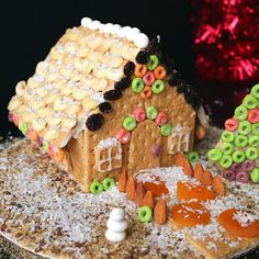 a gingerbread house decorated with candy and pretzels