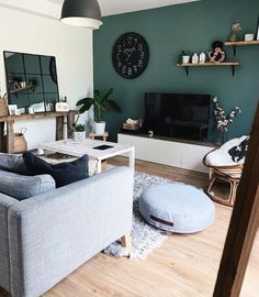 a living room filled with furniture and a large clock on the wall above it's fireplace