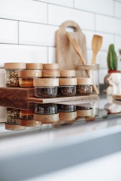 jars and spoons are stacked on top of each other in front of a kitchen counter