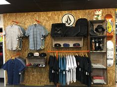 the inside of a store with clothing and hats on display