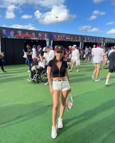 a woman walking across a tennis court holding a racquet in her hand and wearing white shorts