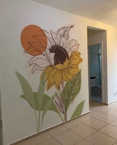 a sunflower painted on the side of a wall in a room with tile flooring