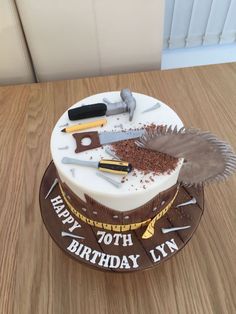 a birthday cake with tools on it sitting on a table