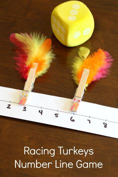 a number line game with two dices and feathers on the table next to it