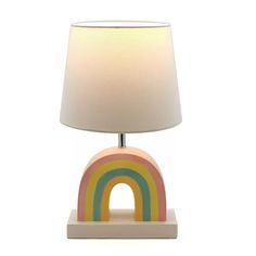 a table lamp with a white shade on it and a rainbow shaped light in the middle