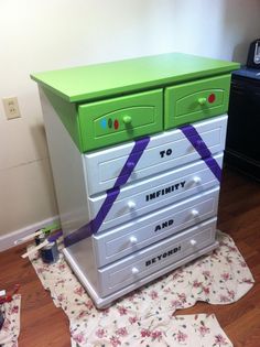 there is a green and white dresser on the floor