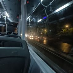 the interior of a bus at night with its lights on and no passengers in it